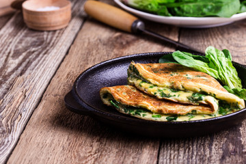 Spinach omelette in cast iron skillet, healthy vegetarian breakfast