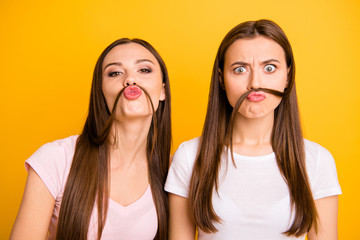 Close up photo two people beautiful she her ladies models send air kisses playing curls make fake moustache crazy facial expression wear white pink casual t-shirts isolated yellow background - Powered by Adobe