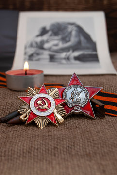 Soviet military order, St. George ribbon, a burning candle on the background of the photograph of the monument. May 9 Russian holiday, the day of victory. 