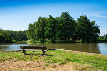 Fototapeta na wymiar grass field and wooden bench in recreation park De Hulk, Hoorn, The Netherlands