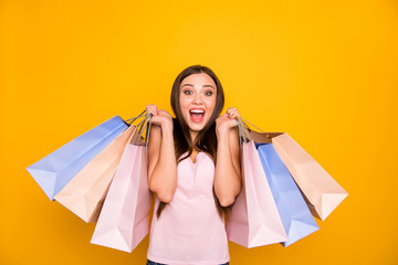 Fototapeta na wymiar Portrait of her she nice-looking cute charming lovely attractive cheerful cheery glad straight-haired girl holding in hands colorful bags isolated on bright vivid shine yellow background