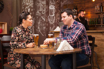 Romantic Couple drinking beer in in a hipster pub and making a toast.