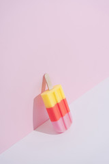 Colorful Ice cream popsicle on pastel pink background. Minimal summer composition.