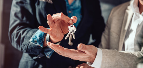 Real estate agent passing apartment keys to a client