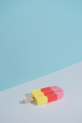 Colorful Ice cream popsicle on pastel blue background. Minimal summer composition.