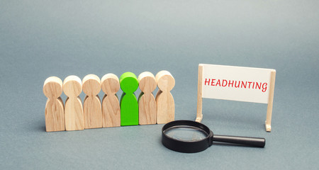 A poster with the word Headhunting, a crowd of people and a magnifying glass. The concept of hiring...