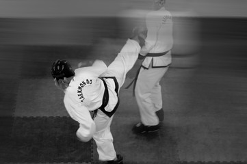 Taekwondo fight. Two men in white kimano. Black and white image. Text: Taekwondo is the name for martial art.