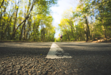 Trip or adventure: Closeup perspective of a street, forest in the blurry background