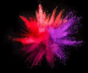 Explosion of colored powder on black background