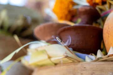 Incense stick burning with smoke for balinese hindu offering ceremony on central street in Ubud, Island Bali, Indonesia . Closeup