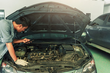 Man asian Car checking  inspection to To take a photo for fix Repair