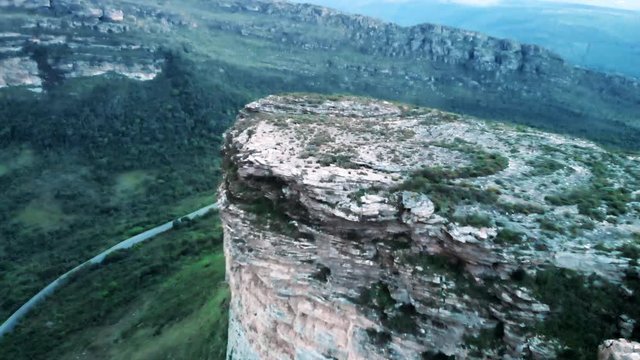 Aerial: Road in Lush Green Valley under Scenic Plateau in Chapada, Brazil