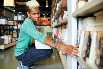 Serious bookstore worker reshelving books 