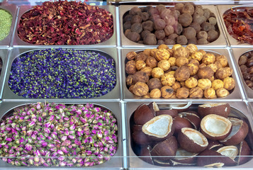 Spice and dried herb counter on the old market, Dubai, UAE. Rose, dried lemon, star anise, mint, coconut halves and hibiscus. Selective focus.