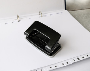 Hole puncher with paper. Object, metallic.
