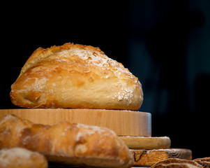 Fresh bread from rye and wheat flour on the table. Composition from a set of bread on a dark background. Bakery.