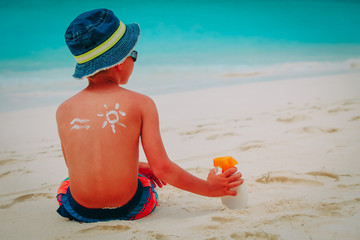 sun protection- little boy with suncream at beach