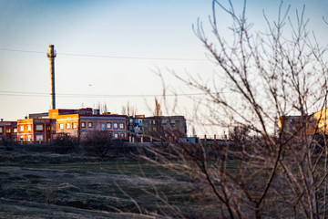 Obraz premium Multi-storey brick houses, construction of residential buildings in the distance, in the Rostov region in Russia. In beautiful light at sunset in cloudy weather.