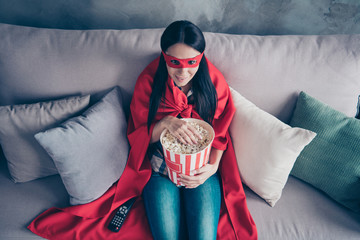High angle top above photo beautiful she her superpower lady costume hold popcorn container watch premiere new long wait comics picture wear red eye mask mantle sit sofa couch divan house indoors