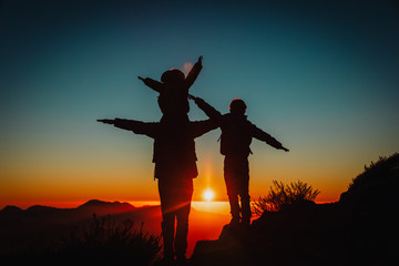 Fototapeta na wymiar father with kids travel in sunset mountains, family hiking in nature