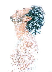 Double exposure of a young bare-chested man’s portrait blended with tree branches and leaves,...