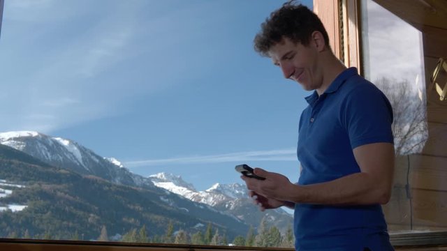 Man Takes a Selfie with Mountain View from Chalet Balcony.