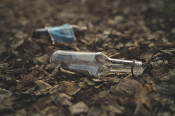 Garbage in the Park or forest, an empty bottle lying on the ground. The concept of environmental pollution, environmental problems of nature.