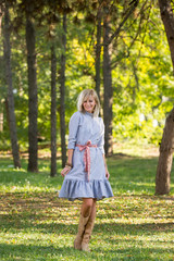 Fashion style portrait of gorgeous beautiful woman posing in summer green park
