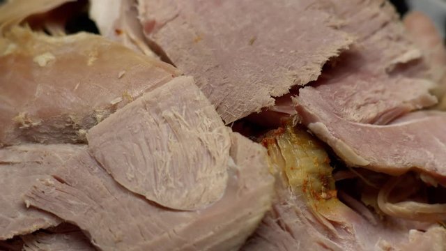 Easter cooked ham sliced on a plate; rotating on a turntable.