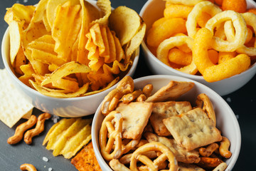 Beer snacks on stone table. Various crackers, potato chips. Top view