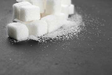 White sugar cubes over black background close up