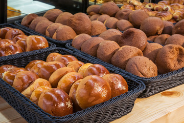 Red bean bun and  mexican coffee bun arranged on the basket at bakery shop for selling.