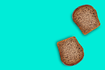 Two rectangular pieces of fresh rye bread on green table on kitchen. Copy space for your text. Top view. Dieting concept