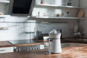 sunlight in kitchen with juicer and glass on wooden surface