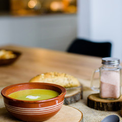 Green vegetable broccoli organic soup in ceramic bowl. Wooden plate with delicious croutons bread. Vegan, organic diet dish.