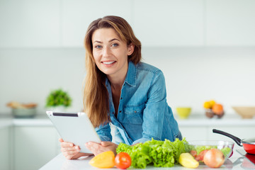 Close-up portrait of her she nice lovely attractive cheerful smart brown-haired lady reading online internet book literature cookery gastronomy dinner lunch delicacy in light white interior style