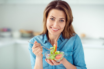 Close-up portrait of her she nice-looking lovely sweet charming attractive cheerful cheery brown-haired lady tasting enjoying new green detox vitamin salad in light white interior style kitchen