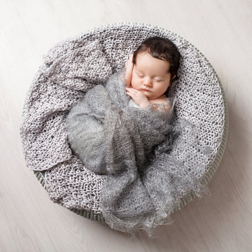 Sweet newborn baby sleeping.  Lovely newborn  2 weeks old lying in the cocon. Copy space