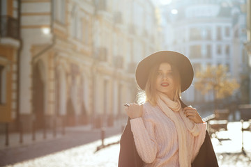 Fototapeta premium Closeup portrait of amazing blonde woman wearing hat and sweater posing with sun light. Empty space