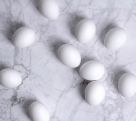 Stylish Set of white eggs on white marble background.