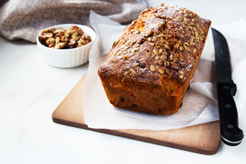 2. Appetizing beautiful bread or loaf cake with nuts, dried fruits on a wooden cutting board. Copy space.