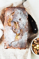 2. Appetizing beautiful bread or loaf cake with nuts, dried fruits on a wooden cutting board.Top view.