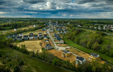 Fototapeta na wymiar Aerial panorama of new construction luxury residential neighborhood street with American single family homes in Maryland USA real estate