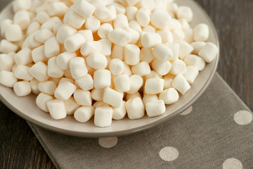 White marshmallow close-up. Marshmallow on a saucer on a kitchen towel. Sweets for dessert.