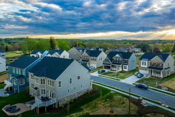 Aerial view of typical American new construction neighborhood street in Maryland for the upper middle class, single family homes USA real estate with dramatic sky