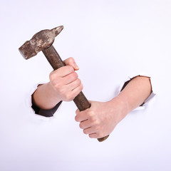 Hammer in the hand of a girl. Symbol of hard work, feminism and labor day. Isolate on white background.