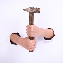 Hammer in the hand of a girl. Symbol of hard work, feminism and labor day. Isolate on white background.