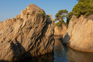 Fototapeta na wymiar Cliffs in sea on Costa Brava coast, Spain. LLoret de Mar seascape. Sea rocky nature in spanish shore