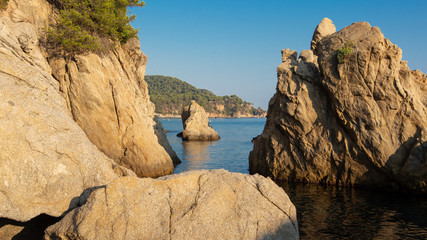 Rocks on Cala de Boadella beach in Lloret de Mar. Scenic sea nature landscape. Cliffs in sea shore in Costa Brava, Spain. Spanish coast