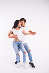 Young couple dancing social latin dance bachata, merengue, salsa. Two elegance pose on white...